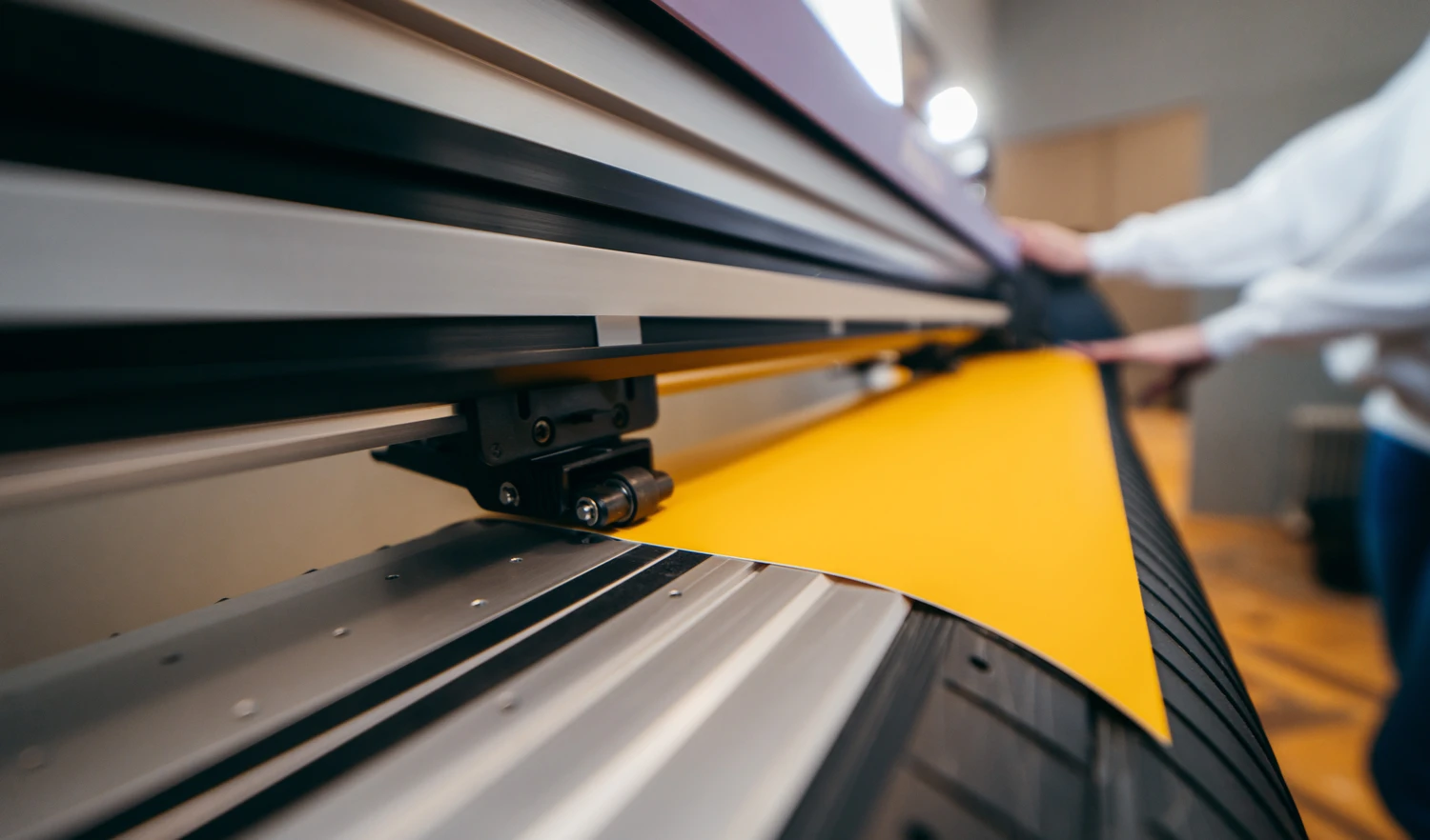 Large printer producing vibrant yellow vinyl for vehicle wraps