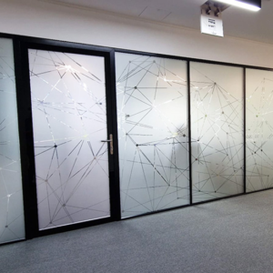 Modern frosted vinyl window film with a geometric design applied to glass partitions in an office.