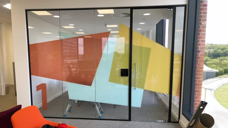 Colourful printed window graphics applied to office glass partitions for a modern and vibrant design.