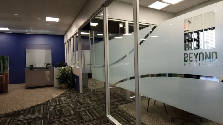 Custom frosted glass window film with a modern design and company logo cutout on office partitions.