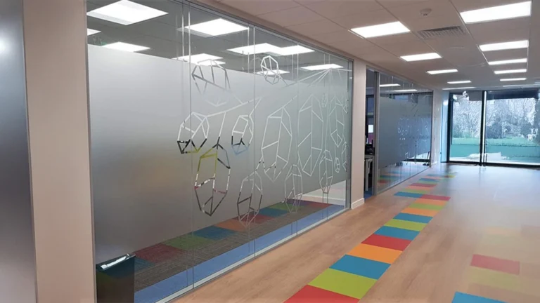 Frosted glass window film with an abstract geometric cut-out pattern applied to office glass partitions for privacy and aesthetics.