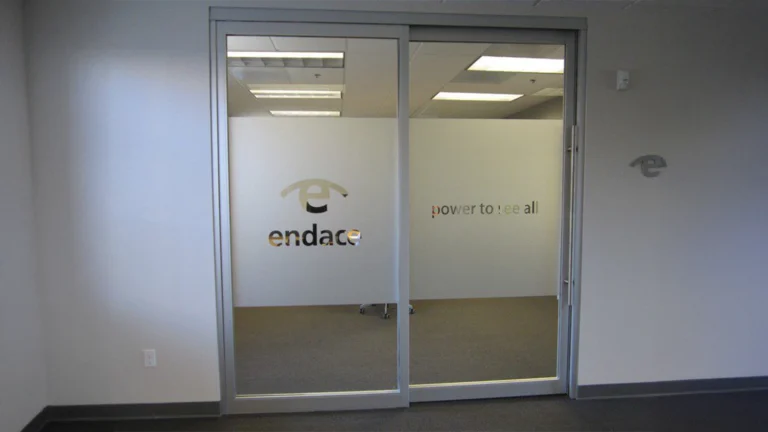 Frosted glass window film with a custom logo cutout applied to an office entrance for branding and privacy.