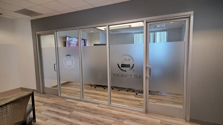 Frosted glass office window film with a company logo cutout applied to glass partitions for privacy and branding.