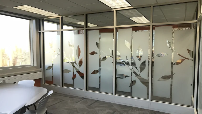 Frosted glass window film with a decorative nature-inspired leaf pattern applied to office glass partitions for privacy and aesthetics.