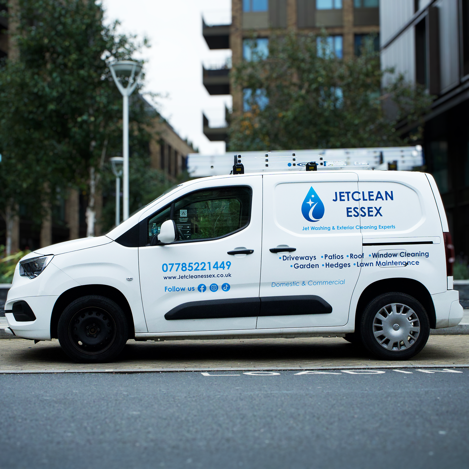 White van with blue and white vinyl decals for Jetclean Essex, advertising exterior cleaning services like jet washing, patio, roof, and window cleaning.