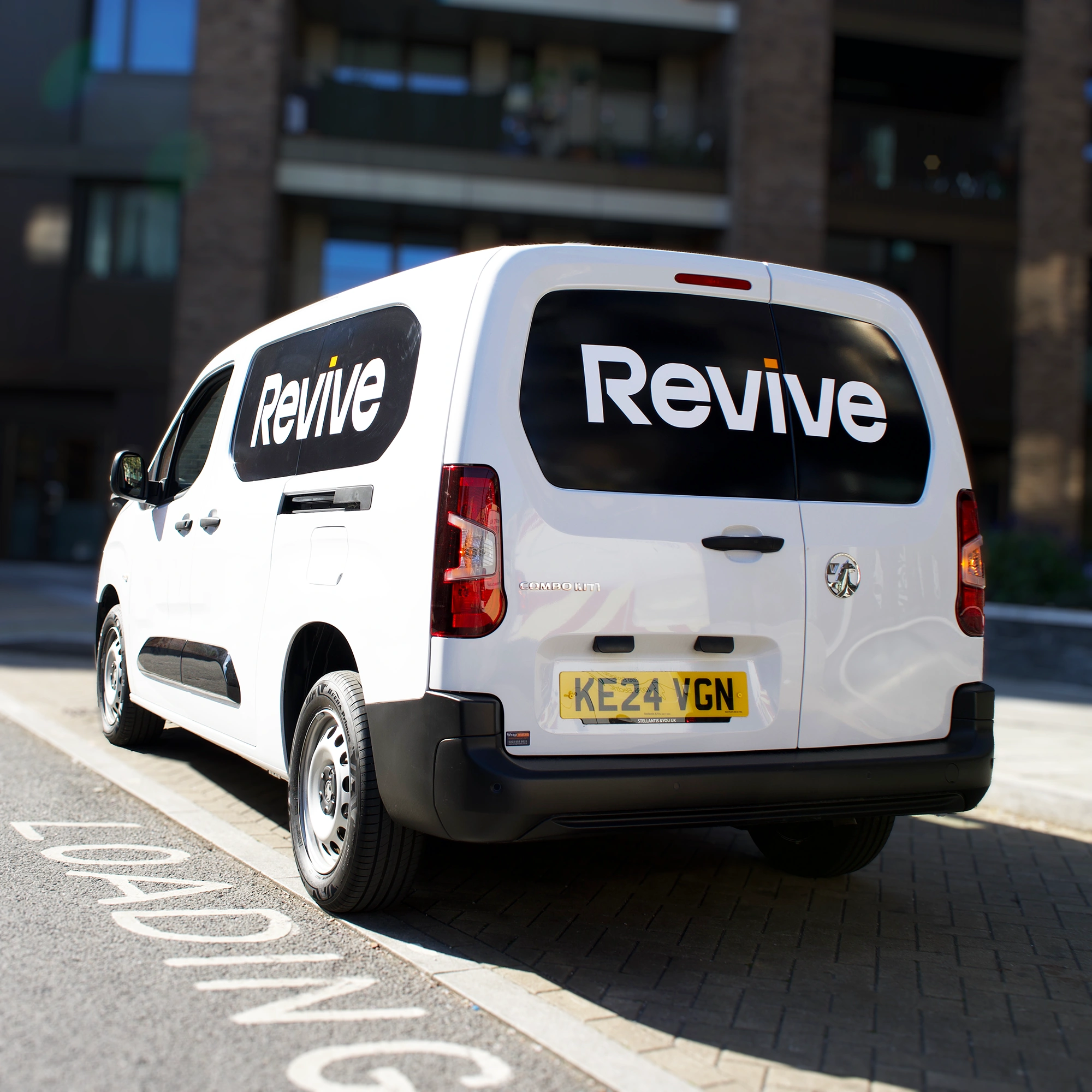 Custom van wrap for Revive commercial vehicle featuring bold black and white vinyl branding in London