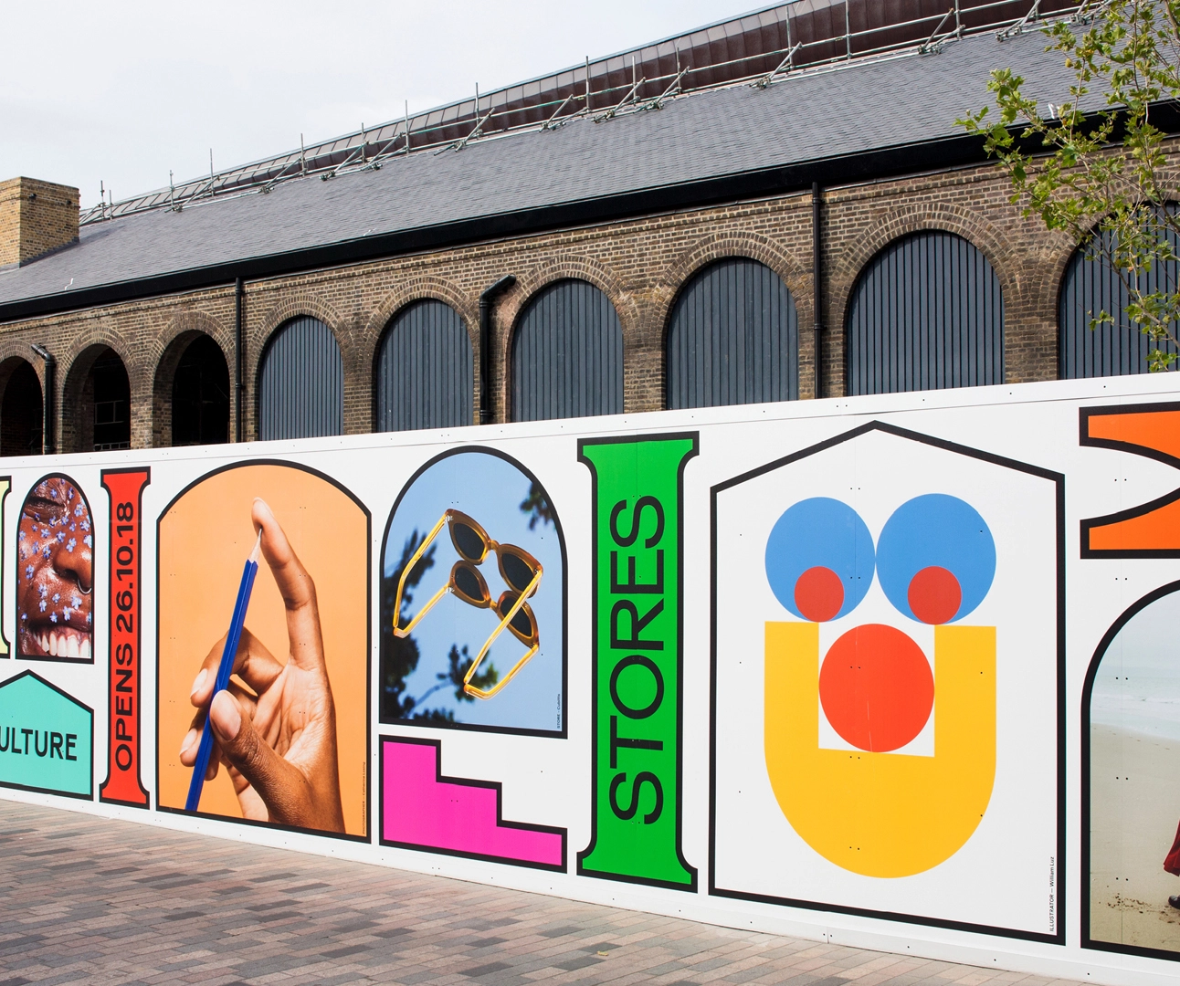Extensive outdoor construction site hoarding featuring a vibrant, multi-panel pop-art style display in a pedestrian plaza.