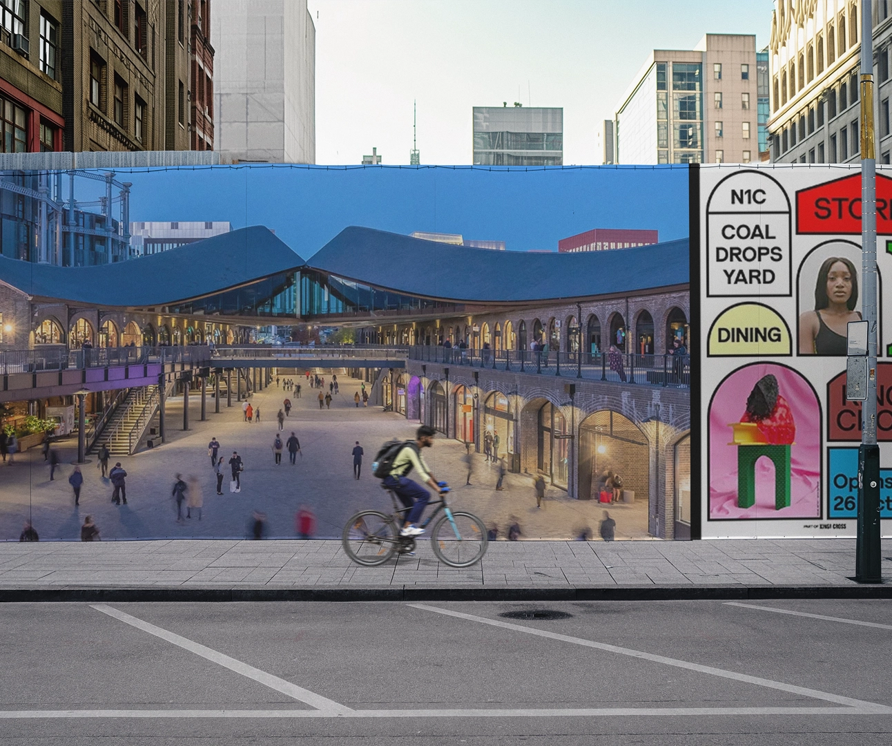 Wide-format outdoor construction hoarding featuring a large-scale photograph of "Coal Drops Yard" and colorful graphic branding panels.