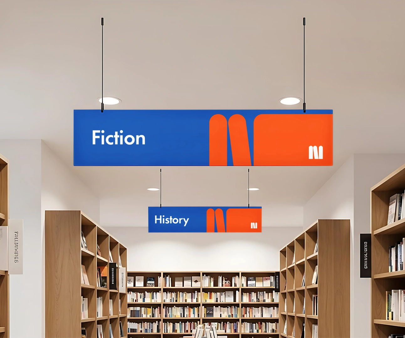 Suspended library wayfinding signs for "Fiction" and "History" sections in a modern bookstore or library.