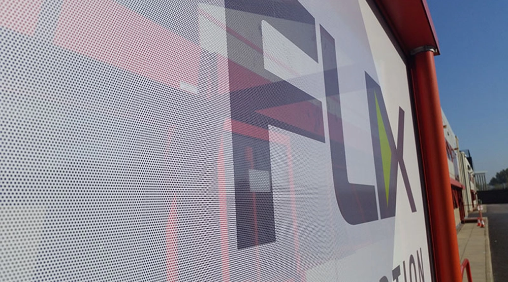A close-up view of a perforated window film featuring a large 'FLX' corporate logo, showing the fine mesh texture that allows for one-way visibility.