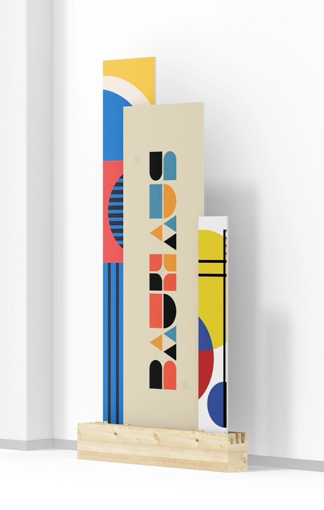 To help you catalog or display this piece, here is the metadata based on the visual content of the image:Image MetadataFieldContentTitleBauhaus Geometric Art Installation in Wooden BaseAlt TextA vertical three-panel art installation featuring Bauhaus-style geometric patterns and typography, set in a natural light wood slotted base against a white wall.