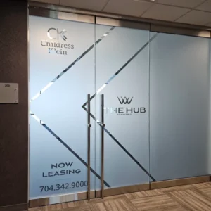 Frosted glass office entrance featuring corporate logos for Childress Klein and The Hub.