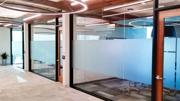 Continuous horizontal band of frosted vinyl on glass office partitions for privacy